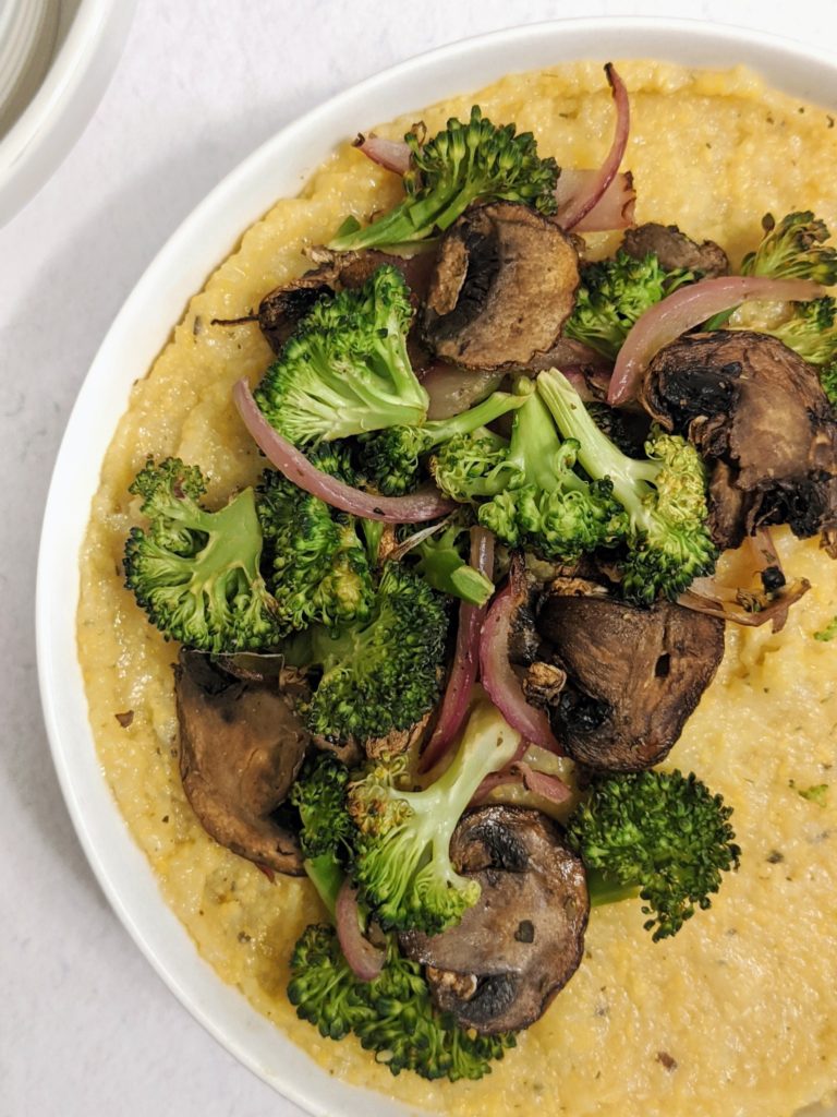 This super creamy Cheesy Vegan Polenta is an easy comfort-dinner that uses pre-cooked/tubed polenta and is ready in 15 minutes. Top it with roasted Broccoli and Mushrooms, and turn that side-dish into an entree.