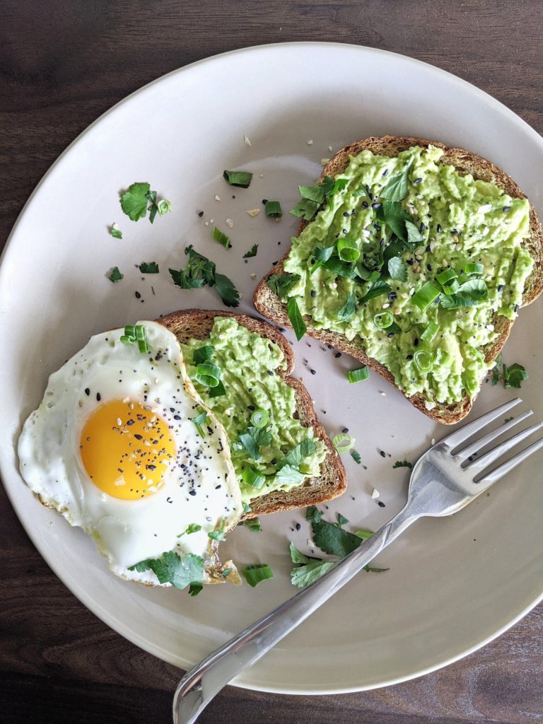 A whole wheat toast with smashed avocado, fried egg and everything bagel seasoning, this is the best avocado toast topping idea!