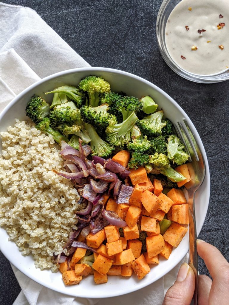 A hearty and healthy Roasted Sweet Potato and Broccoli Buddha bowl topped with a delicious Maple Tahini Dressing: The perfect flavorful Vegan meal! Made with quinoa, this lunch bowl is gluten-free too!