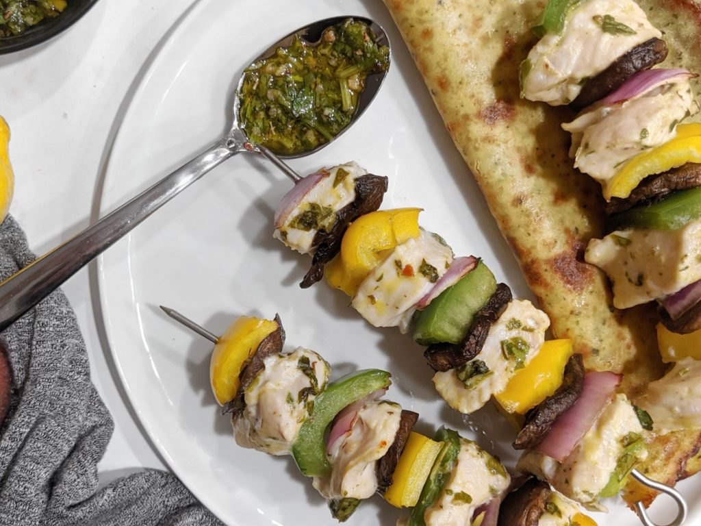 Pieces of chimichurri chicken breast threaded on skewers with peppers and onions and then grilled or baked in the oven to make perfectly juicy kebabs that are paleo, whole30, low carb and keto too!