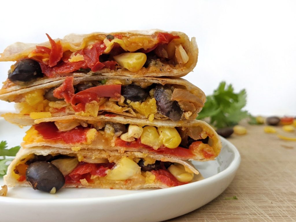 Bright and beautiful Black Bean and Corn Quesadillas full of fiber, flavorful spices and cheesy goodness! A perfect vegetarian recipe for an easy and filling lunch.