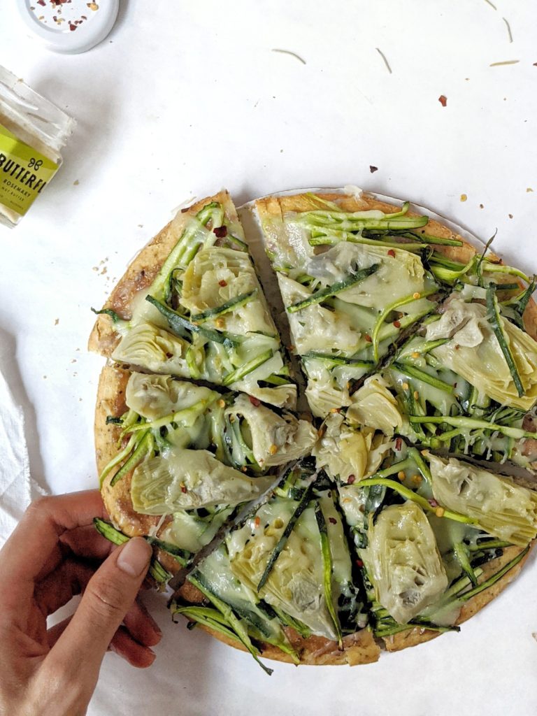 Nutritious and delicious Rosemary Cashew Green Goddess Pizza made with zucchini and artichoke on a rosemary cashew butter pizza sauce. A healthy, easy and cheesy pizza sure to satisfy your cravings!