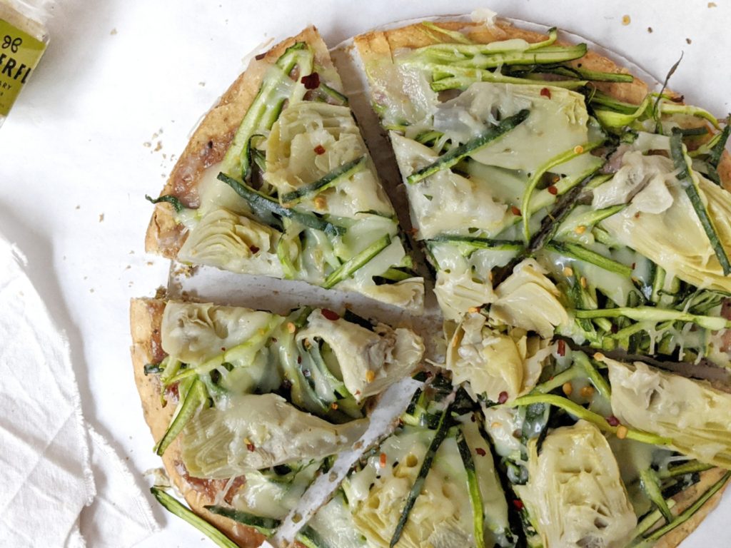 Nutritious and delicious Rosemary Cashew Green Goddess Pizza made with zucchini and artichoke on a rosemary cashew butter pizza sauce. A healthy, easy and cheesy pizza sure to satisfy your cravings!