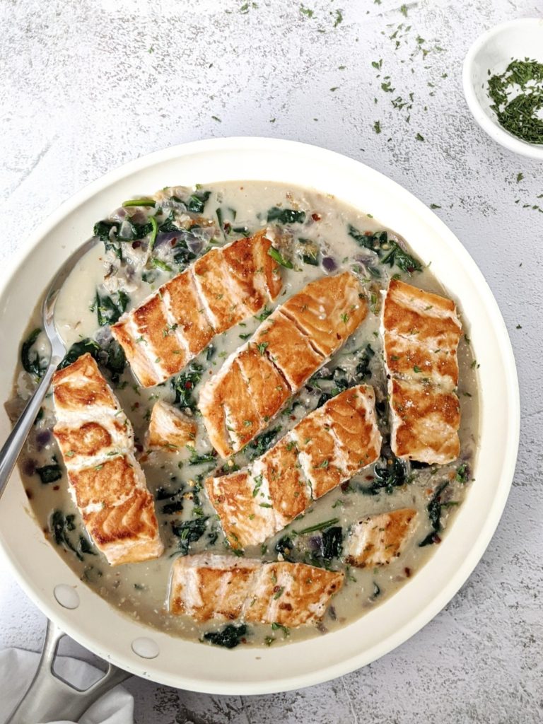Easy Garlic Parmesan Creamed Spinach Salmon for a restaurant quality dinner at home. Pan seared salmon smothered in a cheesy, garlicky, creamy spinach sauce. A delicious and healthy dinner in 20 minutes.