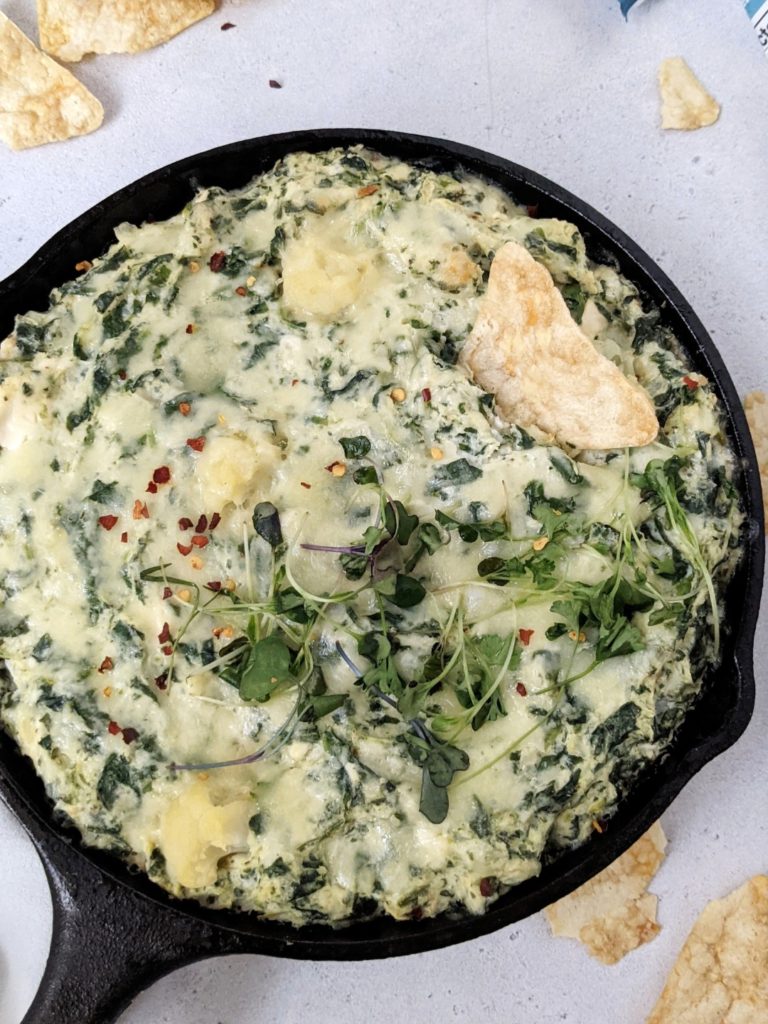 A delicious and easy baked Cauliflower Spinach Cheese Dip made with low fat cream cheese, mozzarella and parmesan, sure to be your new chip & dip go-to. Loaded with nutrition from the cauliflower and spinach, this healthy dip also has Greek Yogurt and no cream!