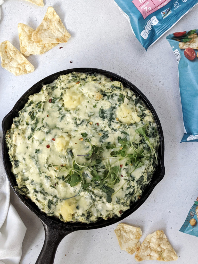 A delicious and easy baked Cauliflower Spinach Cheese Dip made with low fat cream cheese, mozzarella and parmesan, sure to be your new chip & dip go-to. Loaded with nutrition from the cauliflower and spinach, this healthy dip also has Greek Yogurt and no cream!