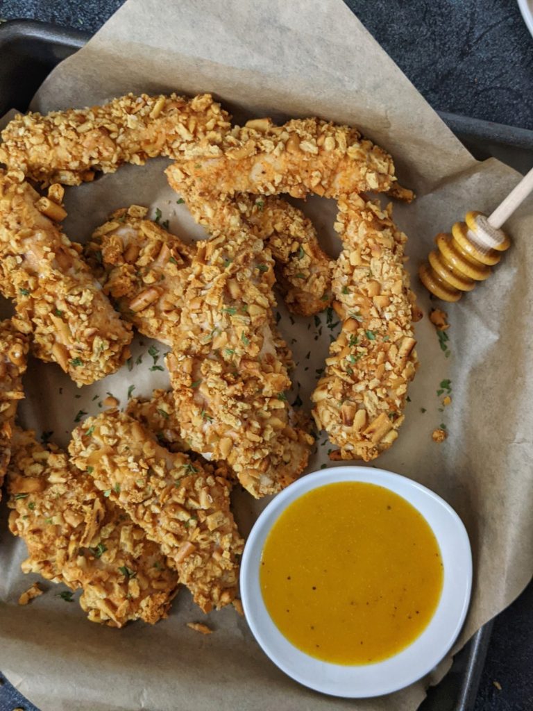 Crispy and crunchy, these Spicy Pretzel Chicken Tenders are baked in the oven or cooked in an air fryer - the best appetizer you can find. With no bread crumbs, these pretzel crusted chicken fingers are healthy and even more perfect with a honey mustard dipping sauce.