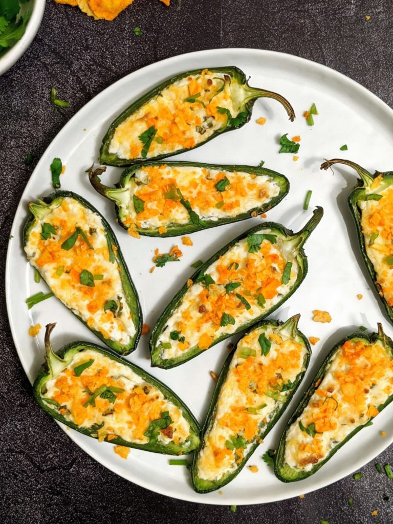 Easy and light Baked Jalapeno Poppers stuffed with cream cheese and cheddar, baked in the oven, and topped with chips! Crispy, creamy and cheesy perfection!