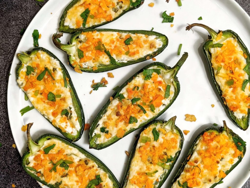 Easy and light Baked Jalapeno Poppers stuffed with cream cheese and cheddar, baked in the oven, and topped with chips! Crispy, creamy and cheesy perfection!