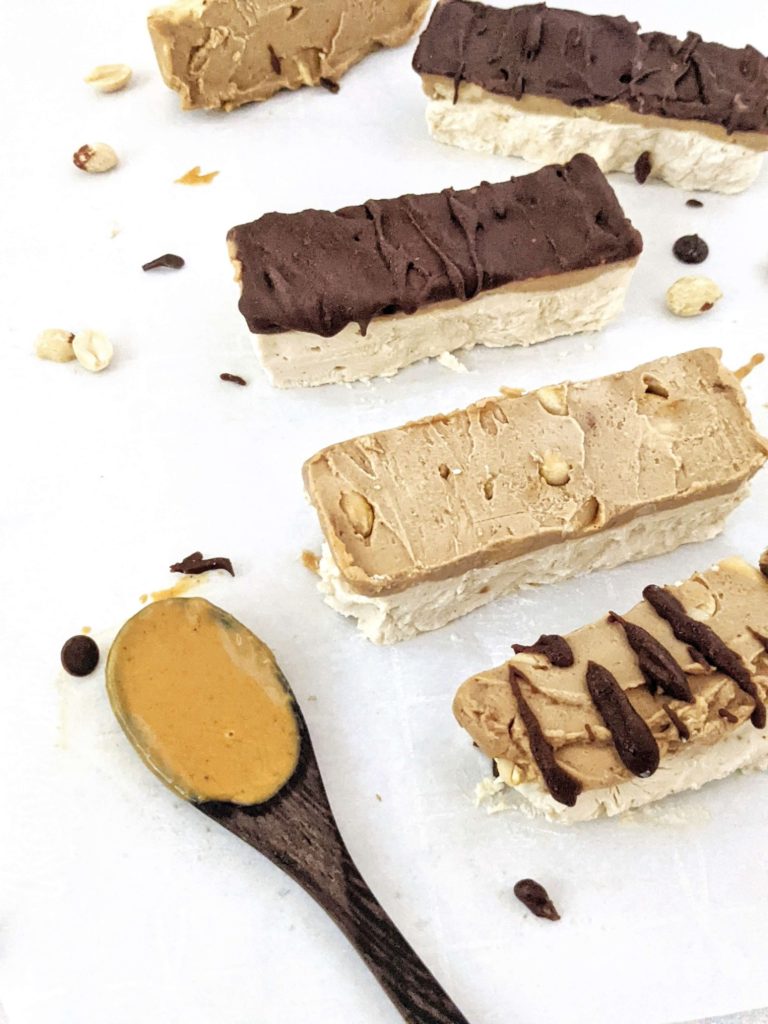 Homemade Protein Snickers Ice Cream bars made with Greek Yogurt and Protein Powder! With layers of peanut butter protein ice cream, sugar free peanut butter caramel, chopped peanuts and chocolate, it’s like eating a healthy protein snickers candy bar as ice cream!