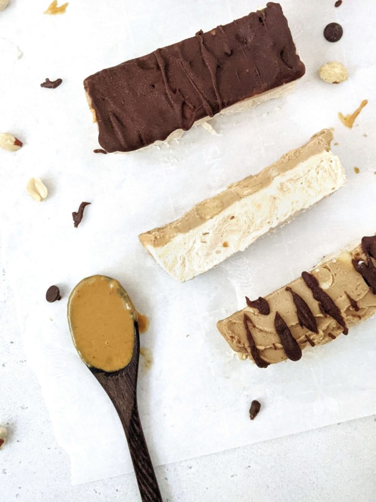 Homemade Protein Snickers Ice Cream bars made with Greek Yogurt and Protein Powder! With layers of peanut butter protein ice cream, sugar free peanut butter caramel, chopped peanuts and chocolate, it’s like eating a healthy protein snickers candy bar as ice cream!
