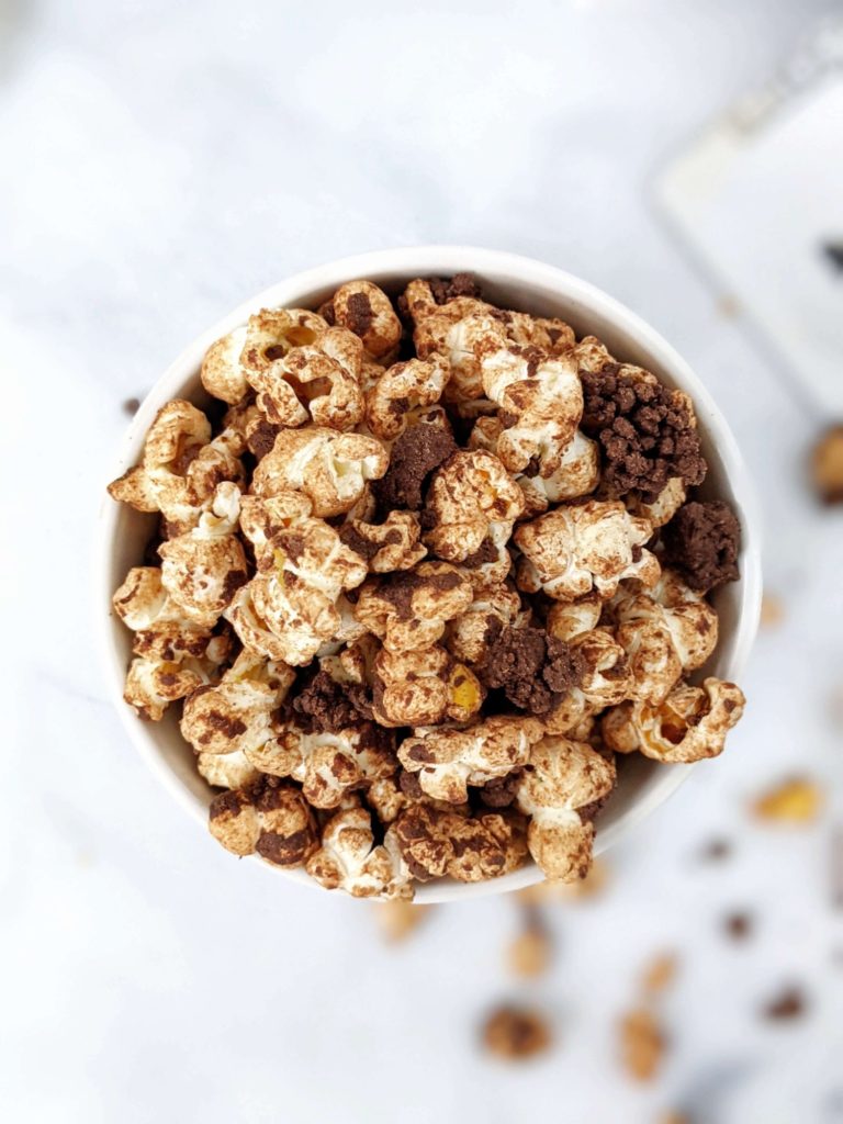 The best double Chocolate Protein Popcorn recipe complete with dark chocolate protein crumbles! This chocolate covered protein popcorn uses protein powder, melted chocolate and almond butter and is quite the perfect high protein snack or dessert.