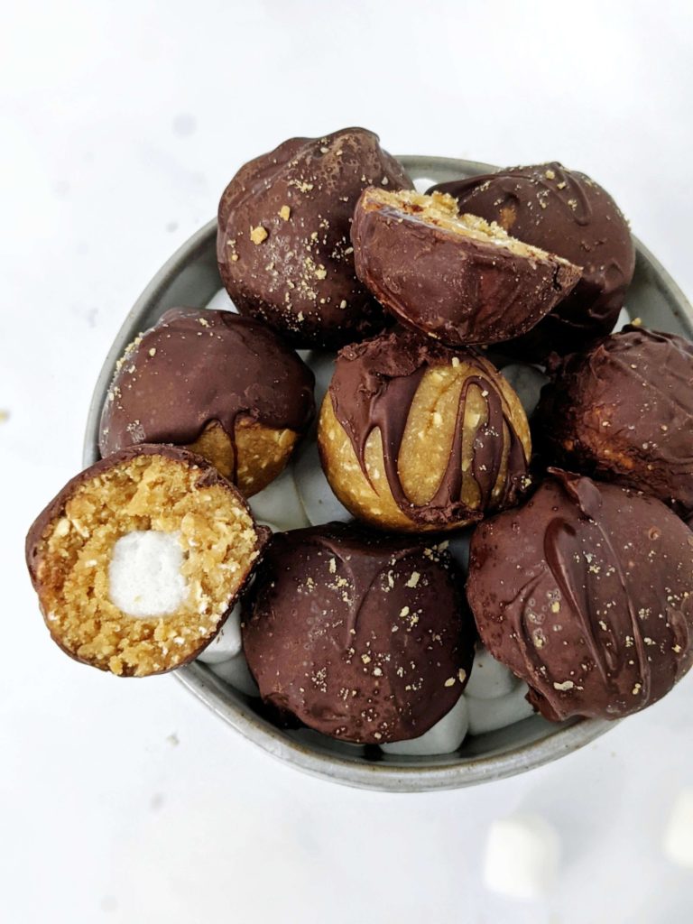 These S’mores Protein Balls are made with graham crackers and marshmallows like a real s'mores desserts, but made healthy with protein powder, collagen and oats! S’mores protein bites are perfect for a snack, dessert or midday energy boost.