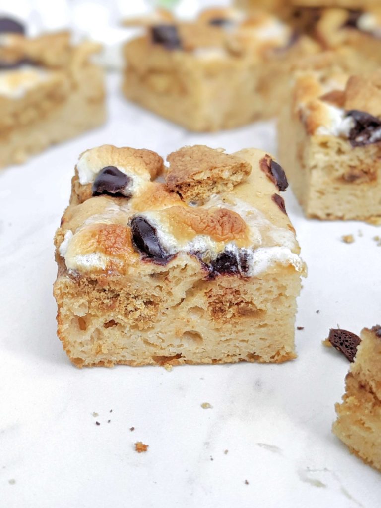 Actually healthy S’mores Protein Blondies made with protein powder and monk fruit instead of sugar, and peanut butter powder instead of oil or butter. These low calorie and low fat protein powder blondies are the perfect healthy S’mores dessert complete with graham crackers, marshmallows and chocolate chips!