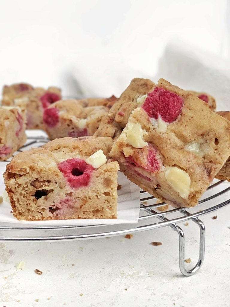 Beautiful White Chocolate Raspberry Protein Blondies make the perfect high protein raspberry dessert for summer! Healthy raspberry blondies use protein powder for sweetener, sugar free white chocolate, and a bit of almond butter, for a low calorie and Vegan raspberry blondie recipe!