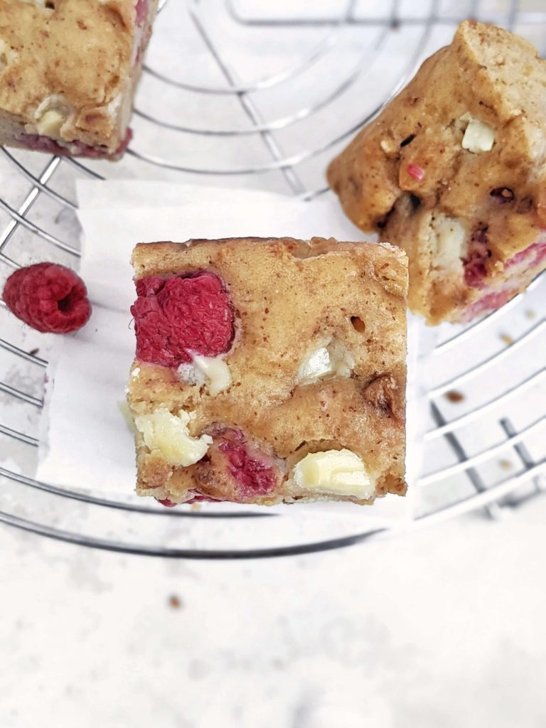 Beautiful White Chocolate Raspberry Protein Blondies make the perfect high protein raspberry dessert for summer! Healthy raspberry blondies use protein powder for sweetener, sugar free white chocolate, and a bit of almond butter, for a low calorie and Vegan raspberry blondie recipe!