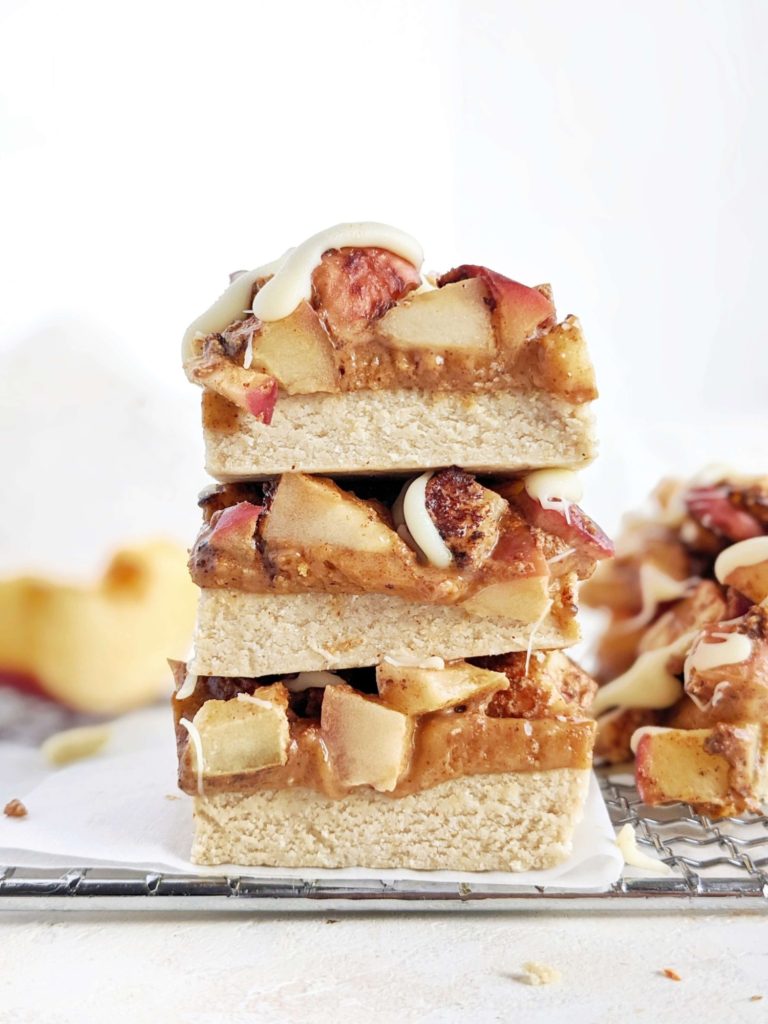 Magical Caramel Apple Protein Bars with 3 layers of protein: pie base, caramel and cinnamon sugar apples! These heathy cinnamon apple protein bars are a great no bake, no sugar energy bar recipe.