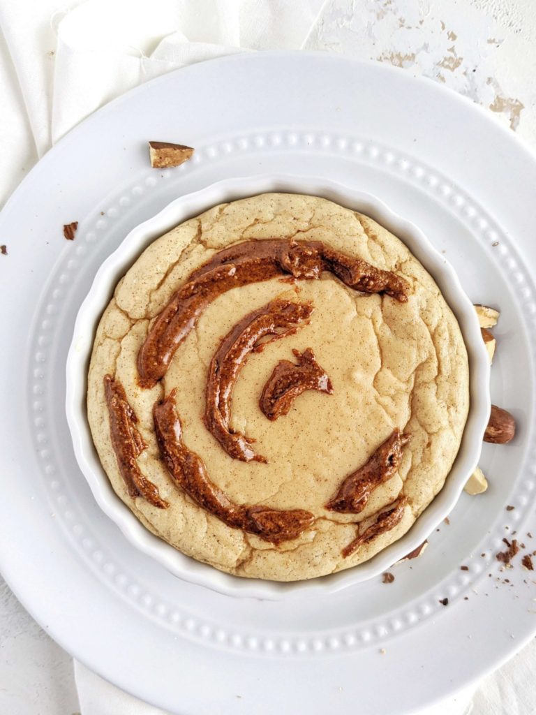 A pretty and pretty Fudgy Cinnamon Protein Mug Cake complete with a swirl and icing. This healthy cinnamon roll protein mug cake uses protein powder, and has no flour or sugar - an easy and keto friendly dessert!