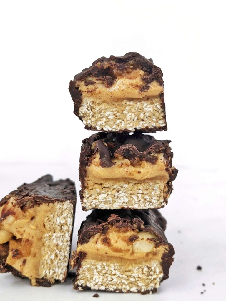 Sweet, chewy and peanutty homemade Snickers Bars that are Vegan, Sugar-free and high in protein too! Made with oat flour, protein powder, peanut butter and stevia-sweetened maple syrup and chocolate, this is the best healthy snickers candy and protein bar out there!