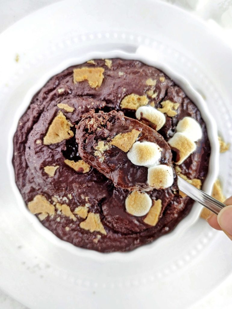 A perfect half baked S’mores Protein Mug Cake made with chocolate protein powder, and complete with grahams and marshmallow! This healthy S’mores mug cake is flourless, sugar free and fat free, but satisfies all the cravings for the summer dessert!