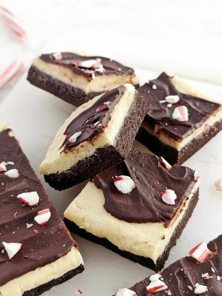 Layered Peppermint Bark Protein Bars with the chocolate peppermint base, thick frosting and chocolate topping - but all sugar free! Healthy, no bake peppermint bars use protein powder instead, as well as oat flour and Greek yogurt.