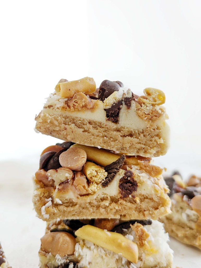Amazing Protein Magic Bars with 7 layers of sugar free treats including protein shake as condensed milk! These healthy protein magic cookie bars are topped with sugar free chocolate chips, coconut, pecans, pretzels and chocolate cereal too. No condensed milk and a keto option too!