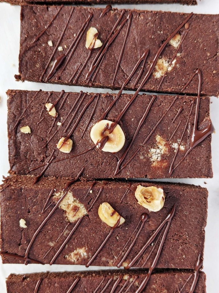 Healthy Nutella Protein Bars inspired by the Ferrero Rocher candy, but sugar free! These Chocolate Hazelnut Protein Bars use a sugar free chocolate nut butter spread and are sweetened with protein powder for a rich chocolate fudge flavor.