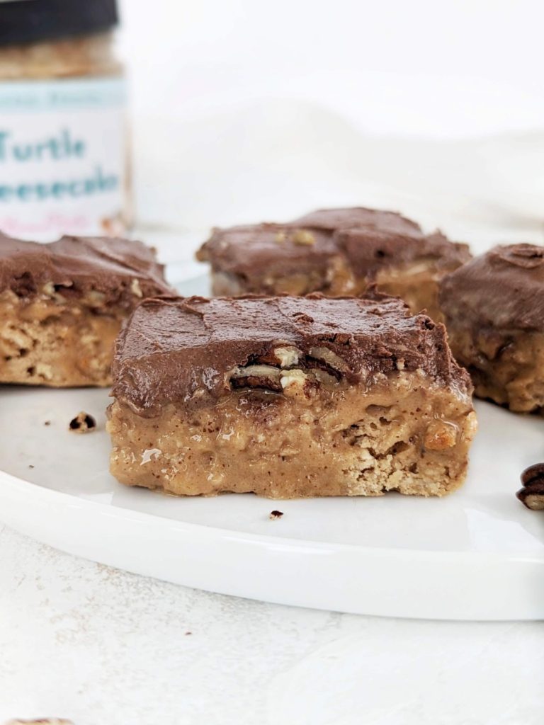 Ooey-gooey Turtle Protein Bars with layers of a caramel-y base, caramel, pecans and chocolate frosting, but all high protein and low sugar! Healthy chocolate caramel pecan turtle bars to satisfy those cravings.