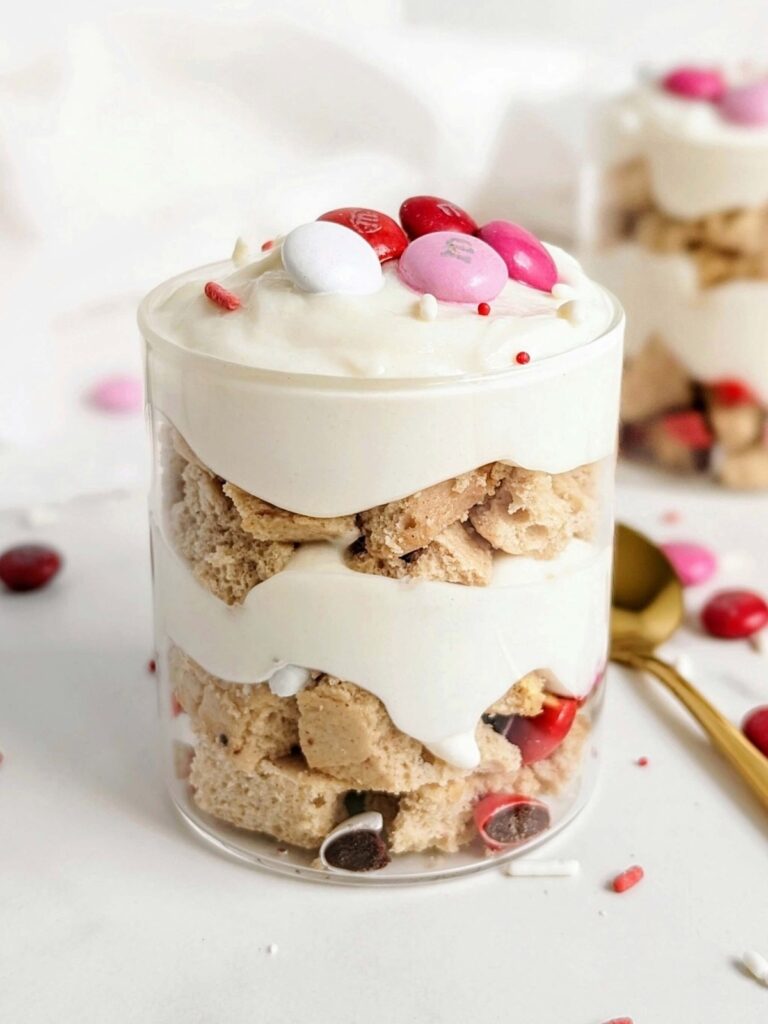 Perfect Valentine’s Day Protein Dessert jars with layers of a protein cookie, protein pudding and Valentines M&Ms. A healthy Valentine’s Day trifle for two made in 5 minutes!