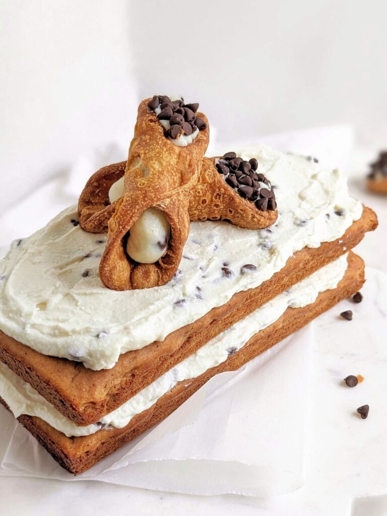 Legit the most amazing Healthy Cannoli Cake - a high protein, sugar free and low fat sponge cake with protein ricotta frosting and sugar free mini chocolate chips.
