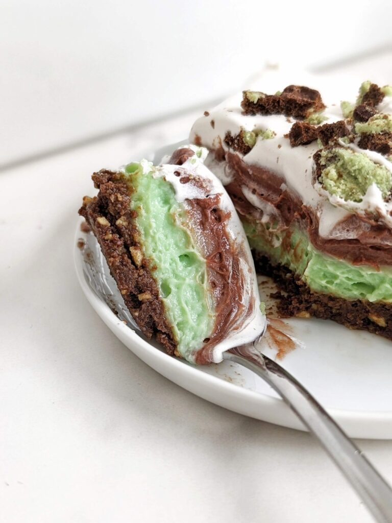 Easy and Healthy Mint Chocolate Dessert with layers of a sugar-free mint chocolate oreo base, mint protein pudding, chocolate protein pudding and low fat cool whip!