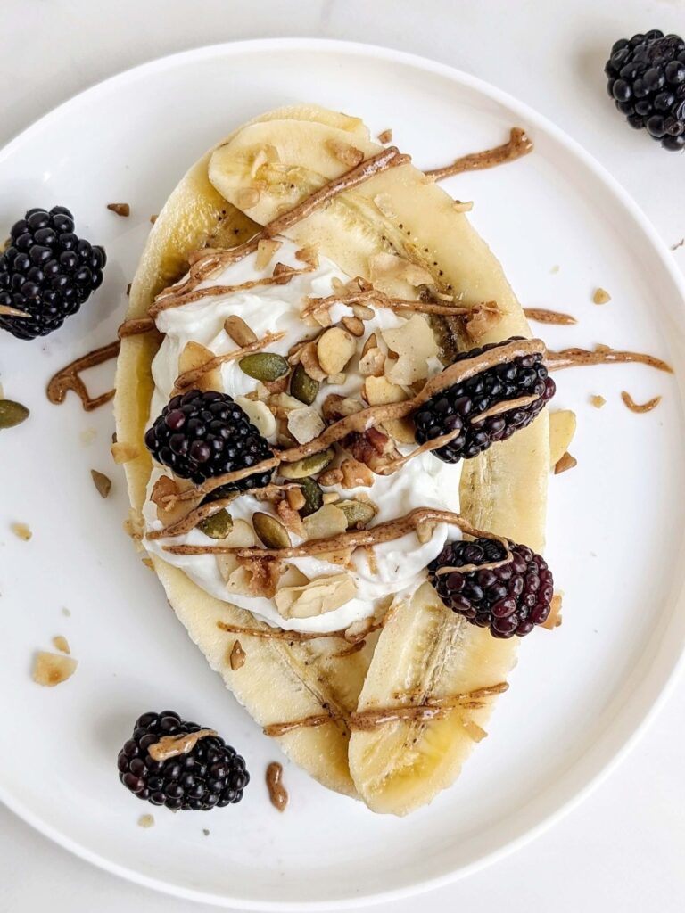 Most easy High Protein Banana Split that’s perfect for a post workout snack or dessert! Healthy banana split has a protein powder yogurt mix, sugar free granola, berries and a protein almond butter too!