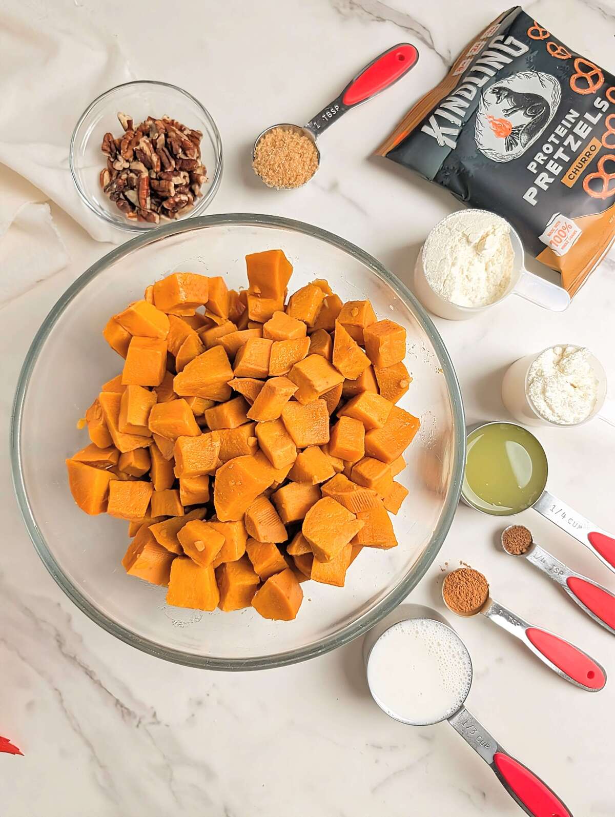 High protein sweet potato casserole is the best healthy Thanksgiving dessert recipe. A sweet potato souffle base with protein powder and a topping with protein pretzels - delicious and macro-friendly!