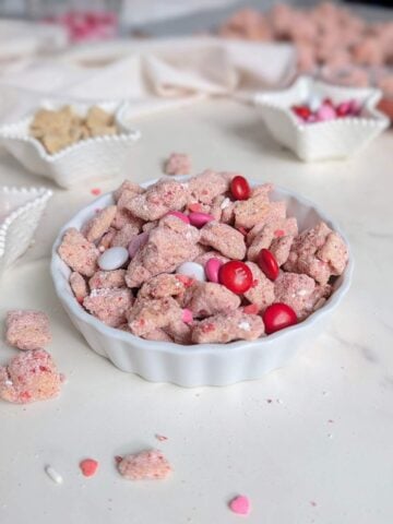 A healthy Valentine's Day Muddy Buddies recipe made with protein powder and naturally colored with freeze-dried strawberries. This Pink Puppy Chow is the perfect sweet, high-protein snack without the red food dye.