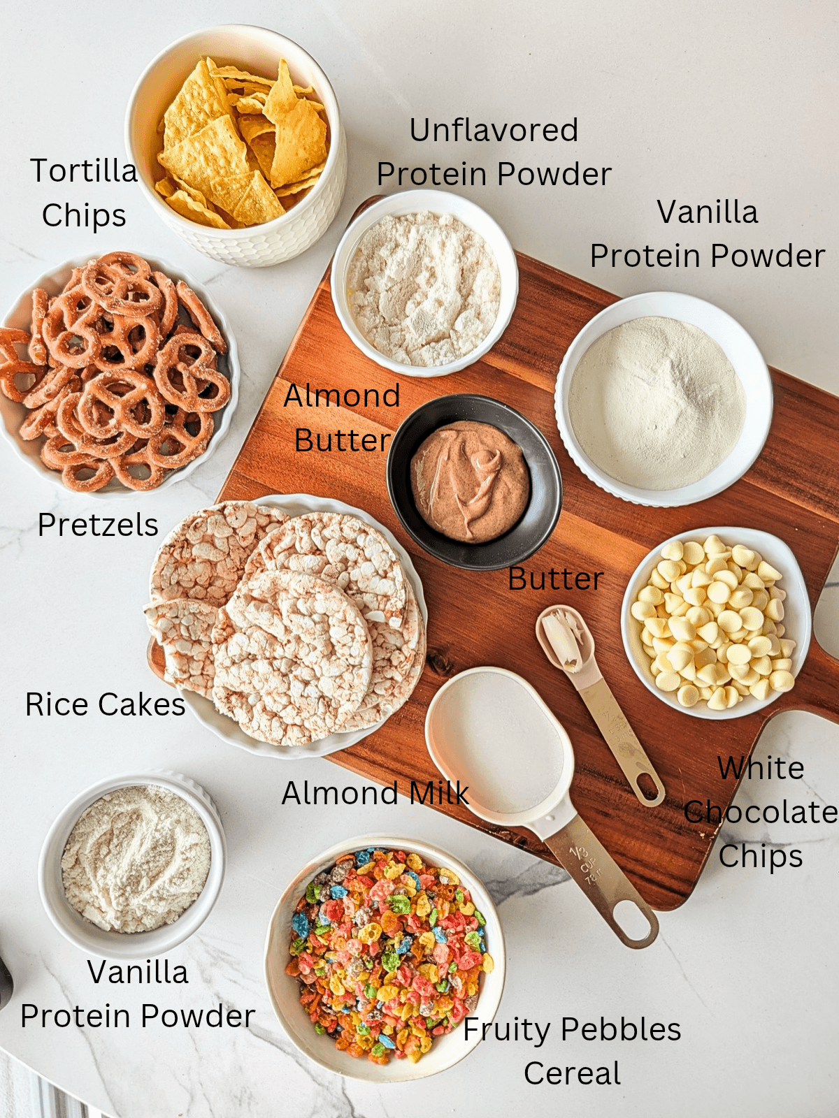 Ingredients for Protein Fruity Pebble Puppy Chow! A high-volume, healthy rainbow muddy buddies with pretzels, rice cakes, tortilla chips and a fruity pebbles protein coating.