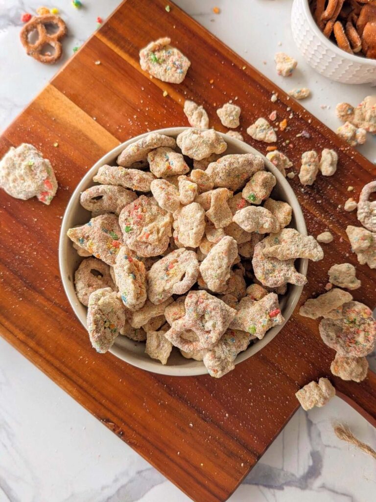 Crunchy, nostalgic Protein Fruity Pebble Puppy Chow! A high-volume, healthy rainbow muddy buddies with pretzels, rice cakes, tortilla chips and a fruity pebbles protein coating.